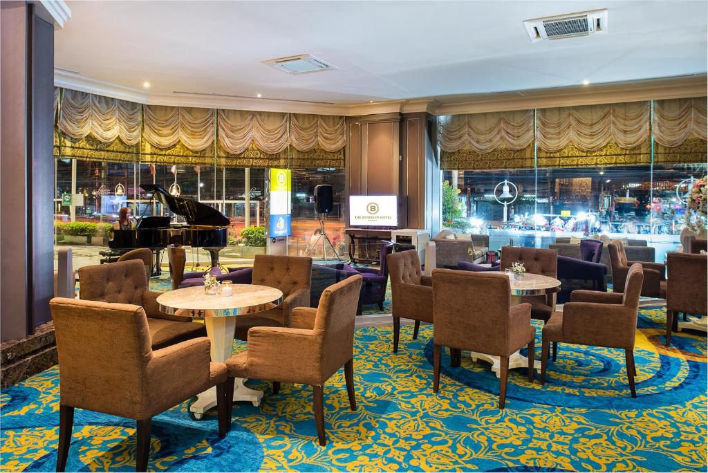 a restaurant with tables and chairs and a piano at The Berkeley Hotel Pratunam in Bangkok