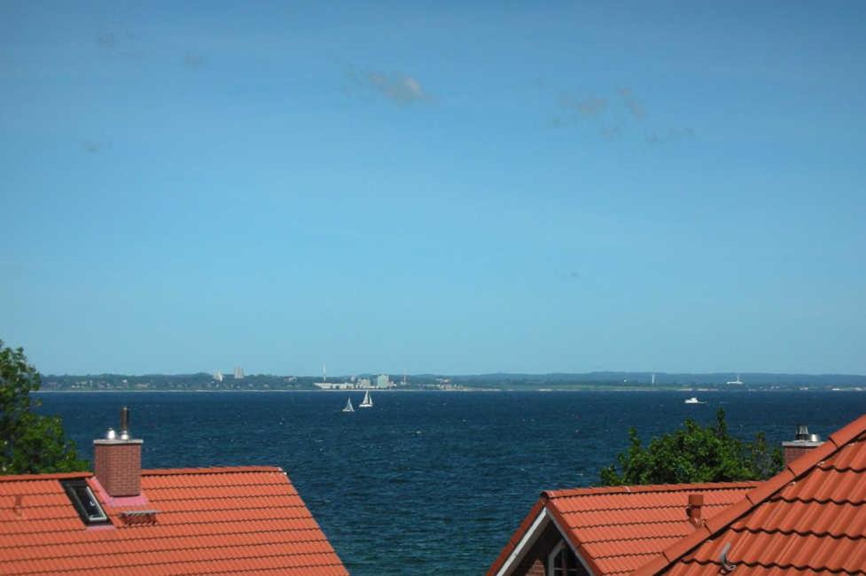 uma vista de uma grande massa de água entre telhados em _OST18_ _ Ferienwohnung Muschelsuc em Niendorf