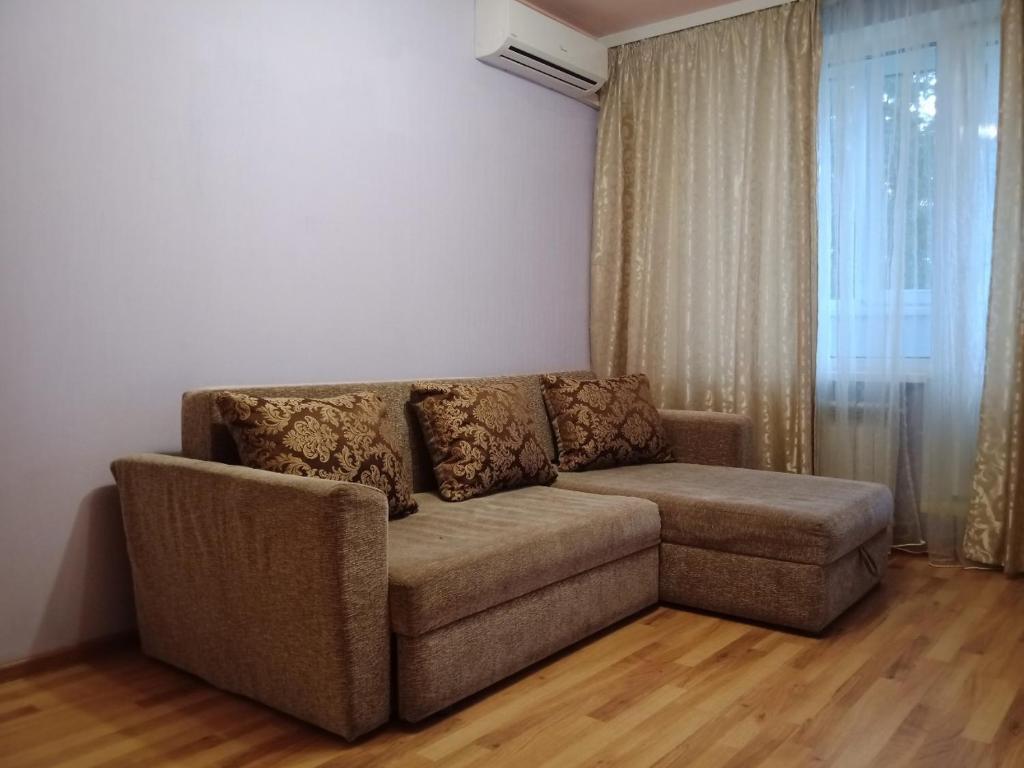 sala de estar con sofá y ventana en 2 к квартира между двумя станциями метро Студенческая и Академика Павлова en Járkov
