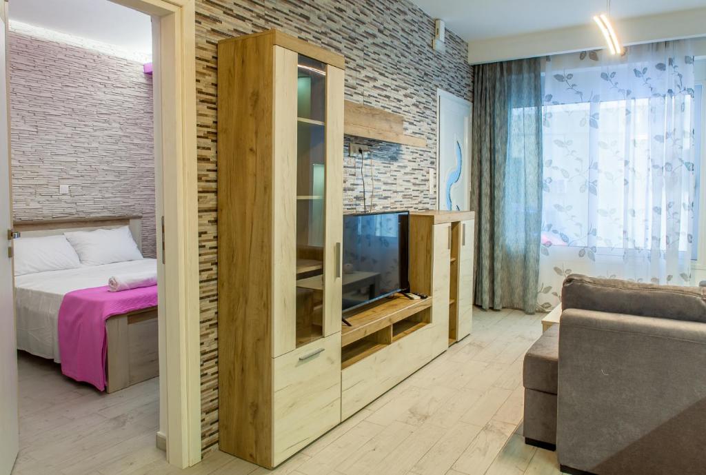 a bedroom with a tv and a brick wall at Alley To The Beach in Ierapetra