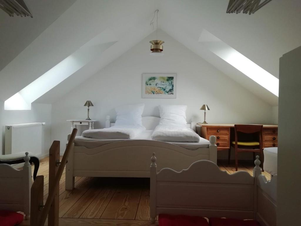 a bedroom with a white bed in a attic at LatterLy Apartments in Voel
