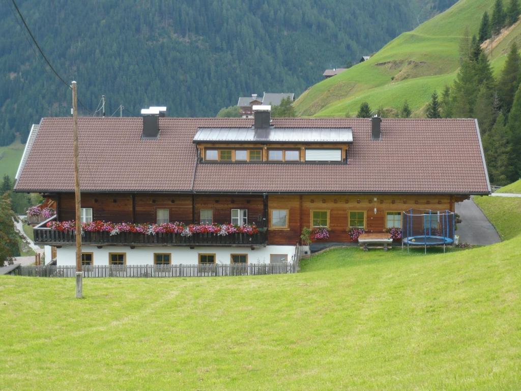 a house on a hill with a green field at Goserhof in Innervillgraten