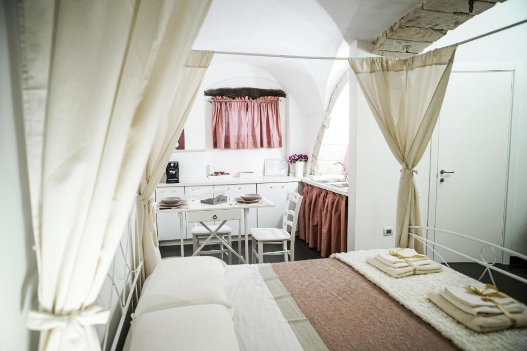 ein kleines Schlafzimmer mit einem Bett und einer Küche in der Unterkunft HOME 5 - Arco Antico in Putignano