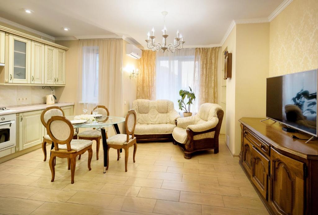 salon ze stołem, krzesłami i kanapą w obiekcie Apart Reserve Sloboda Suite w Iwano-Frankiwsku