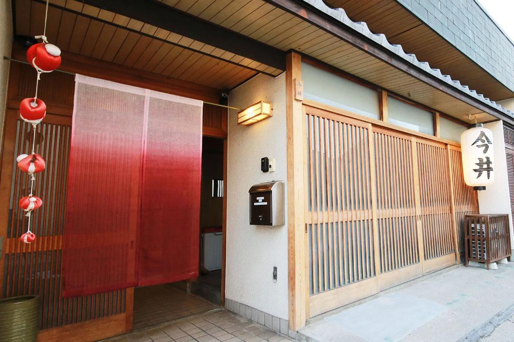 una entrada a un edificio con una puerta roja en Nara Imai House, en Nara