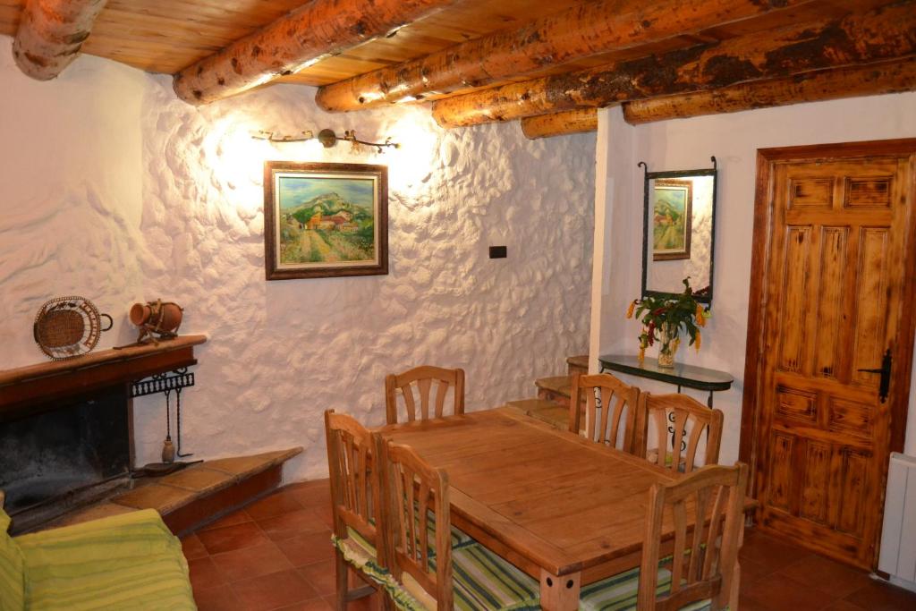 a dining room with a wooden table and a fireplace at Casas Rurales La Tejeruela in Yeste
