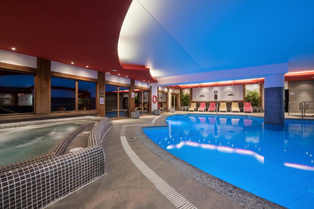 una gran piscina en un hotel con un edificio en CGH Résidences & Spas Les Clarines, en Les Menuires