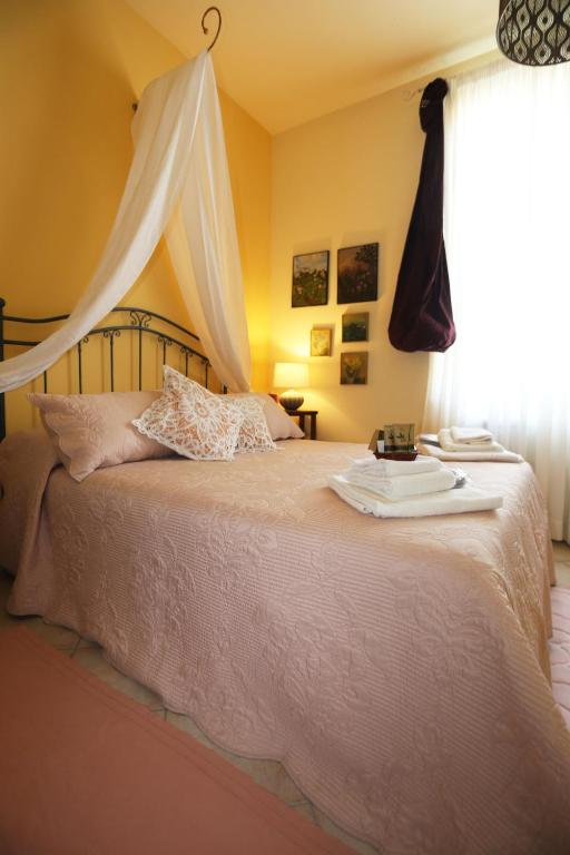 una camera da letto con un letto bianco con una finestra di LIGURIA home ad Ameglia