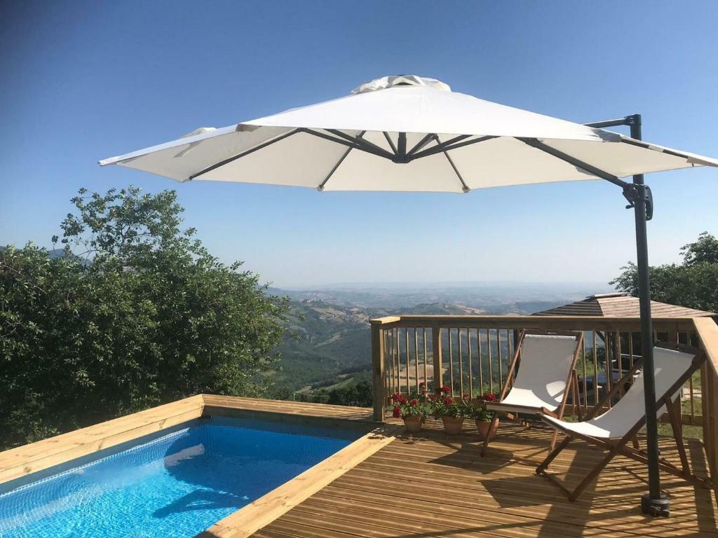 een witte paraplu op een terras naast een zwembad bij Belvilla by OYO Casa grande in Corvara
