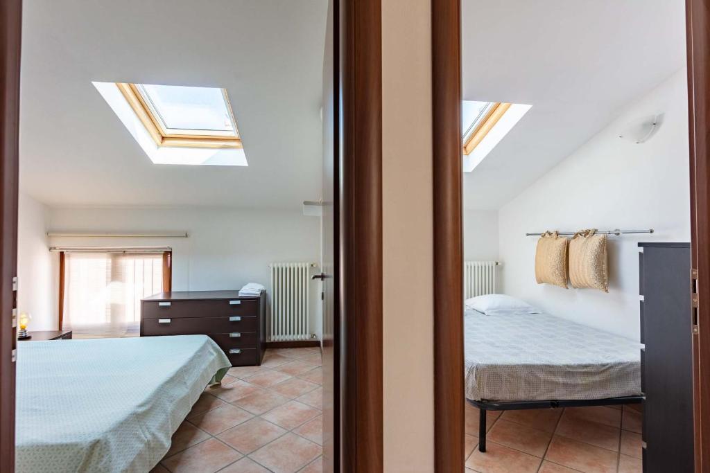 a bedroom with two beds and a window with skylights at La Cà del Picia in Garda