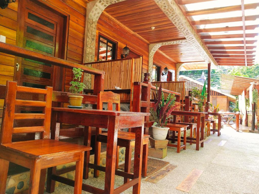 una fila de mesas y sillas de madera en un restaurante en Forest wood-Port Barton, en San Vicente