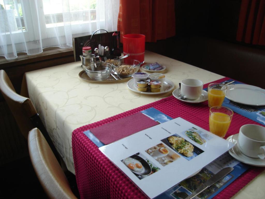 a table topped with a table with a box of breakfast foods at Hotel Milan B&B in Ringgenberg