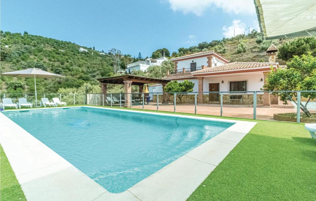 una piscina frente a una casa en Awesome Home In Cmpeta With 5 Bedrooms, Wifi And Swimming Pool, en Cómpeta