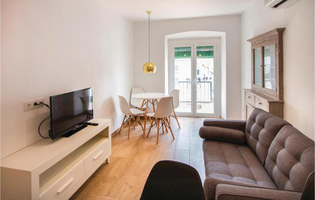 ein Wohnzimmer mit einem Sofa, einem TV und einem Tisch in der Unterkunft Amazing Apartment In Blanes With Kitchen in Blanes
