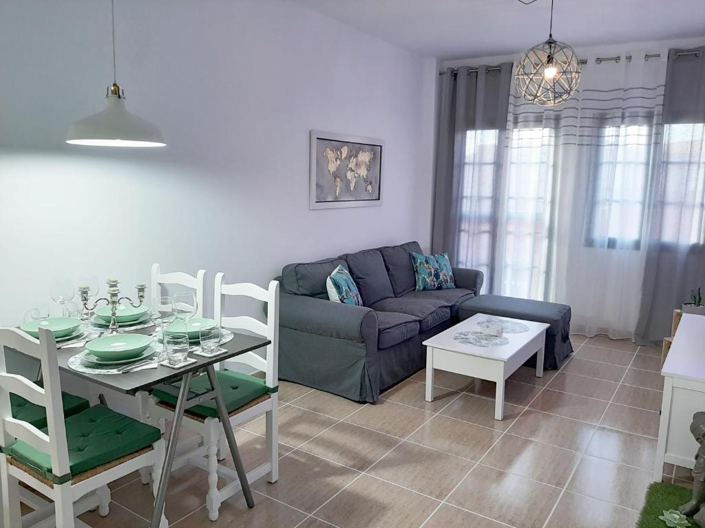 ein Wohnzimmer mit einem Tisch und einem Sofa in der Unterkunft Casa Cactus in Pájara
