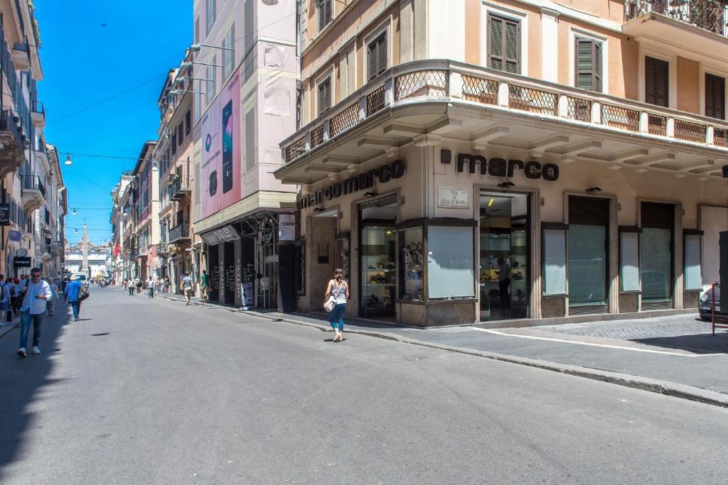 a woman walking down a street in front of a store at Piazza di Spagna Luxury Apartment in Rome