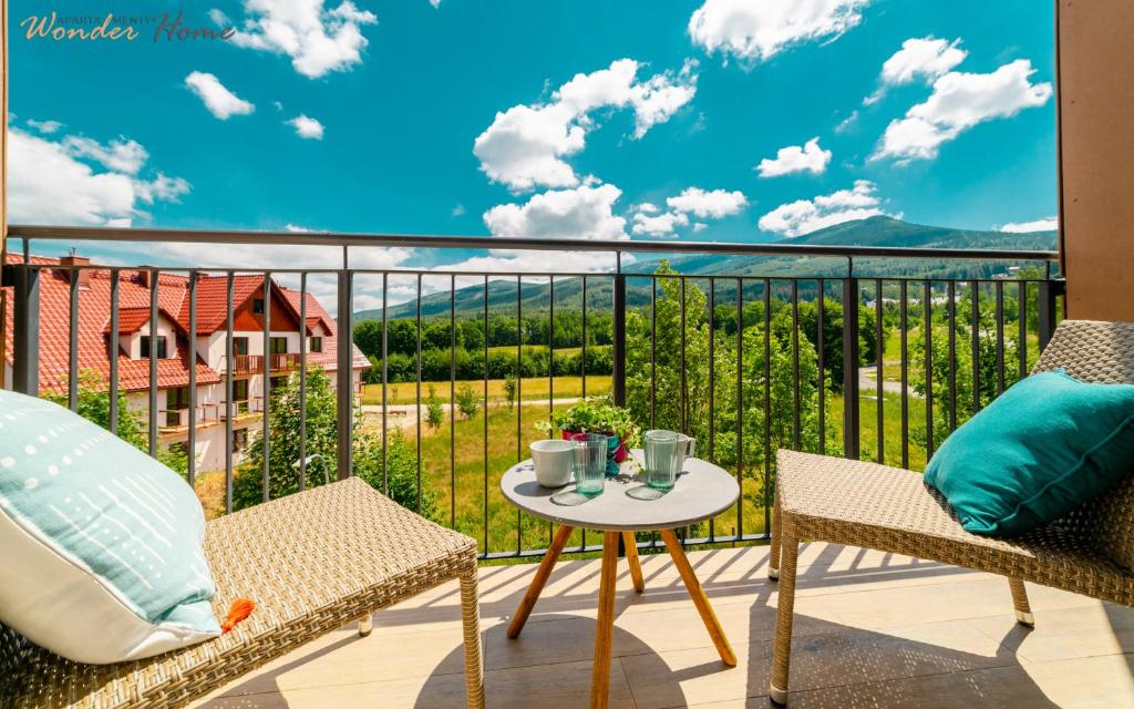a balcony with chairs and a table with a view at Wonder Home - Apartamenty w malowniczej okolicy z balkonami i widokiem na góry in Karpacz