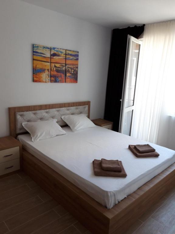 a bedroom with a large bed with two towels on it at Tiffany Boutique Suits - Pomorie in Pomorie