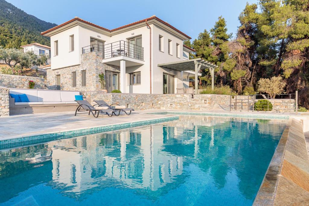a house with a swimming pool in front of a house at Elios Private Living in Neo Klima