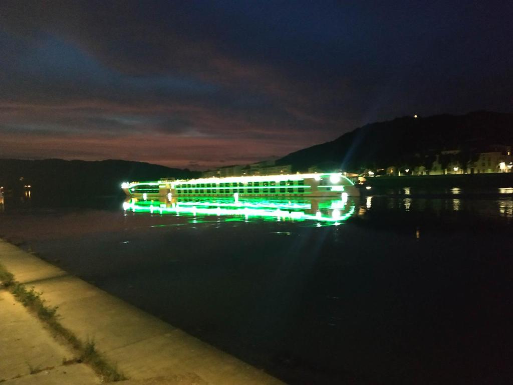a lit up building on the water at night at Le Château in Tournon-sur-Rhône
