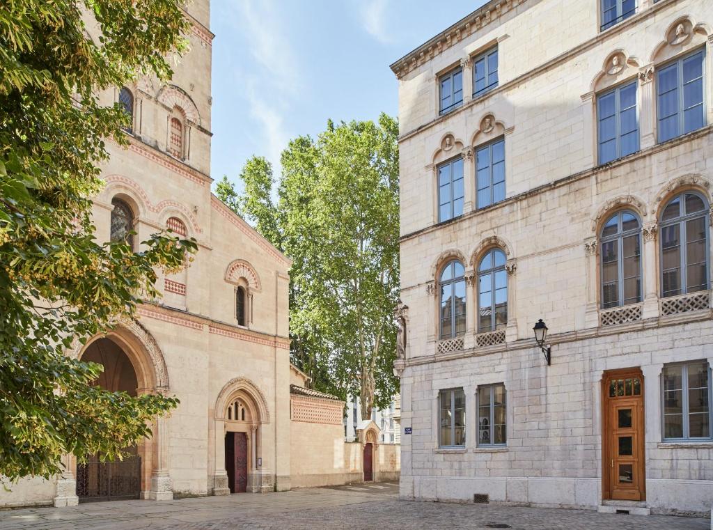 Hôtel de l'Abbaye Lyon - Boutique Hôtel في ليون: مبنيان بجانب بعضهما في شارع