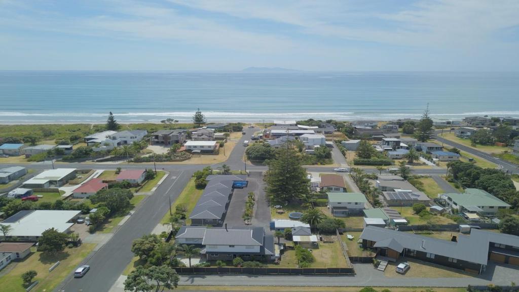 uma vista aérea de uma pequena cidade perto do oceano em Beaches Motel em Waihi Beach