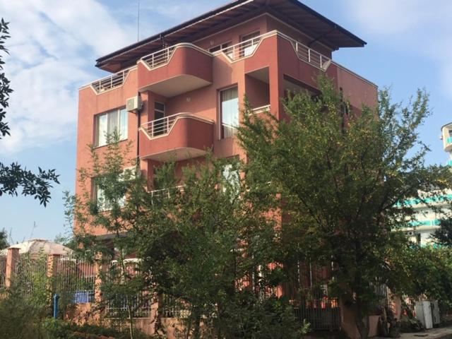 a tall red building with trees in front of it at Свети Кирил Лозенец in Lozenets