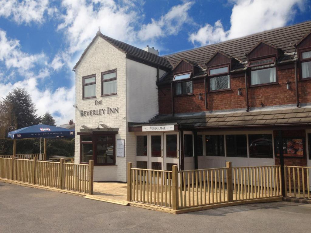 a white building with a fence in front of it at Beverley Inn & Hotel in Edenthorpe