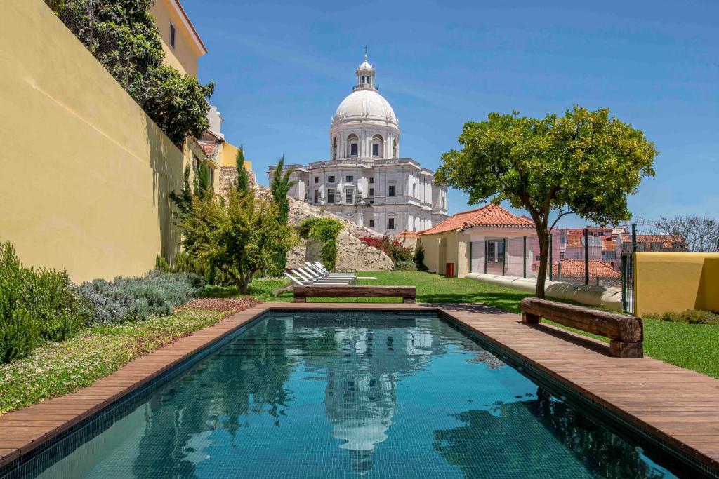 a swimming pool with a building in the background at Tandem Palacio Alfama Suites in Lisbon