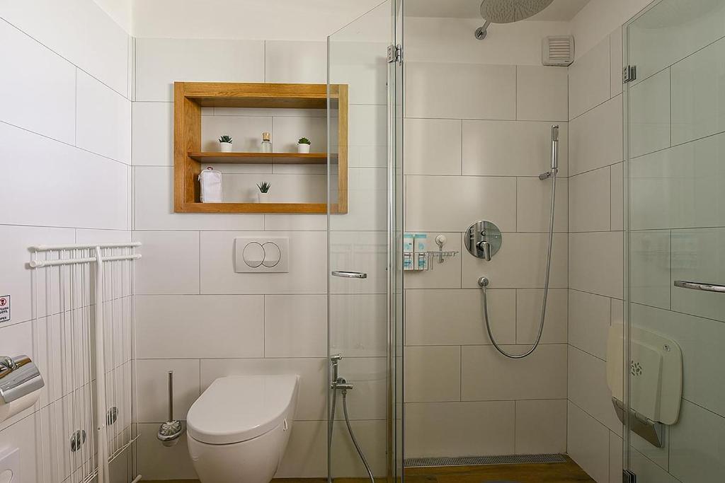 biała łazienka z prysznicem i toaletą w obiekcie Apartment Balthazar w Rovinj