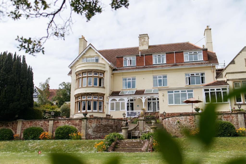 ein großes Haus mit einer Steinmauer in der Unterkunft Northfield Hotel in Minehead