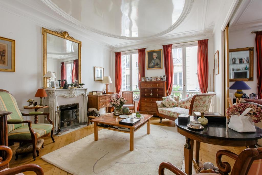 un salon avec une table et une cheminée dans l'établissement Charming apartment - district Vaugirard by Weekome, à Paris