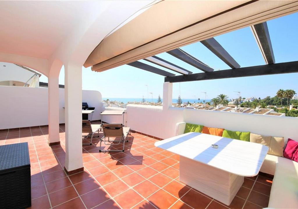 balcón con mesa y vistas al océano en Apartment AMARA, en Estepona