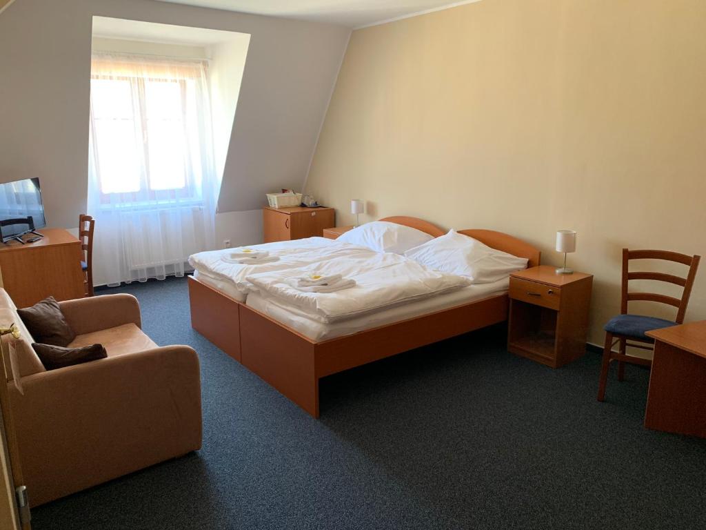 特普利採的住宿－Lázeňský dům Florentini，一间卧室配有一张床、一张沙发和一把椅子