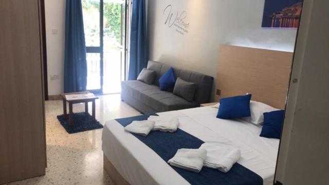 sypialnia z dużym łóżkiem z niebieskimi poduszkami i kanapą w obiekcie Le Malte House St. Julians w mieście St. Julian’s