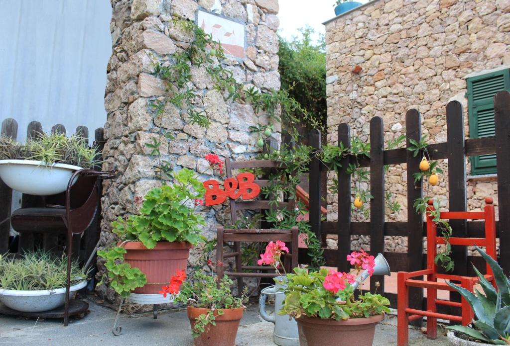 a fence with potted plants and flowers on it at Segni e Impronta in Finale Ligure