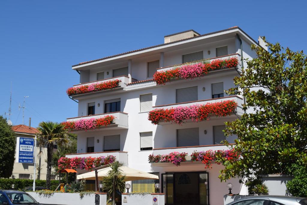 un edificio de apartamentos blanco con flores en los balcones en Orchidea Marina, en Tirrenia