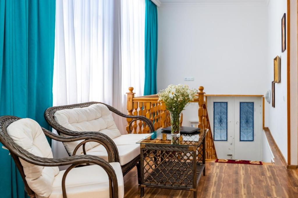 sala de estar con 2 sillas y mesa en Guest House Nana en Tiflis