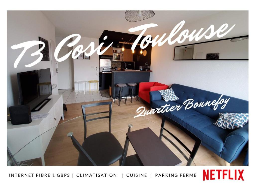 a living room with a blue couch and a kitchen at T3 Bonnefoy in Toulouse