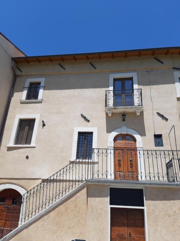 an apartment building with a balcony and a wooden door at Casa Iacobucci in Fagnano Alto