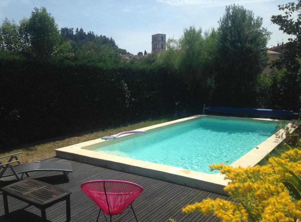 a swimming pool with two chairs and a table at CHAMBRE CENTRE VILLE Coté soleil in Forcalquier