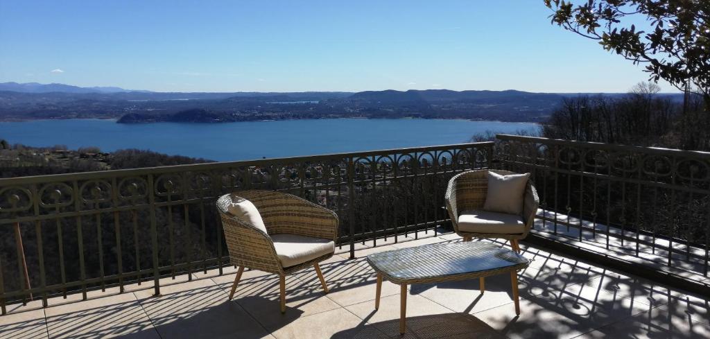 a balcony with two chairs and a view of a lake at Villa Magnolia BB, Lago Maggiore (Massino Visconti, Italy) in Massino Visconti