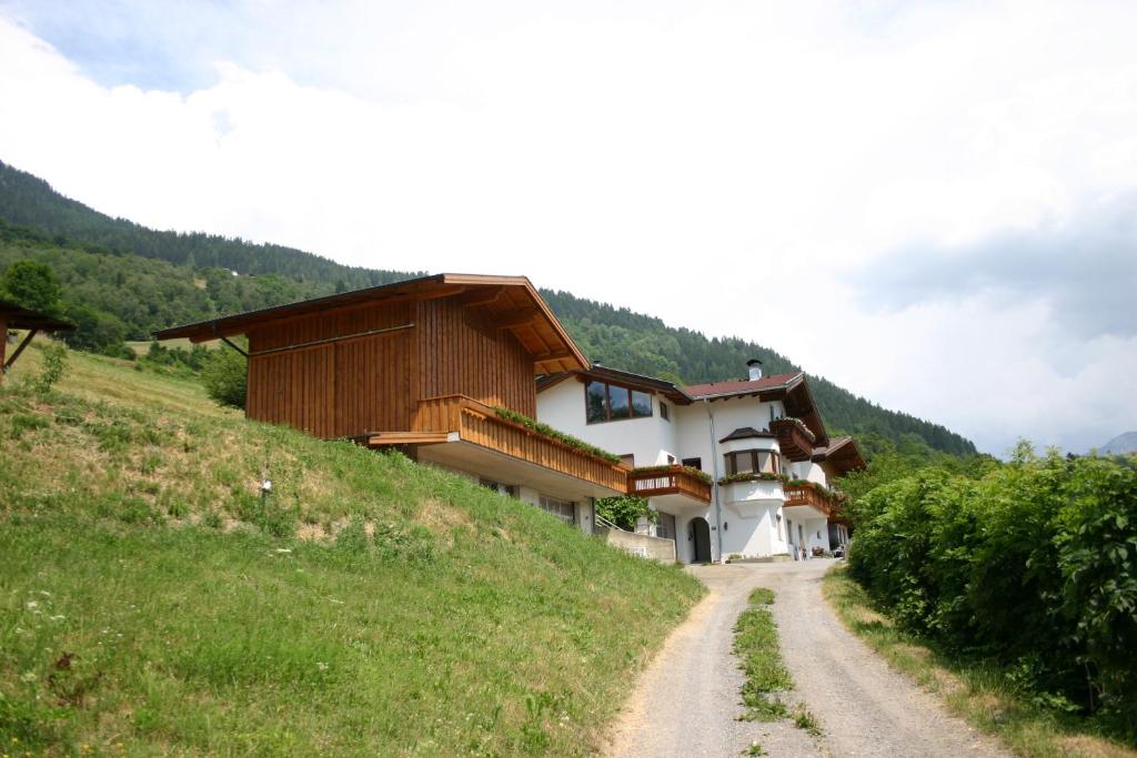 una casa en una colina al lado de un camino de tierra en Ferienwohnung Christina Gundolf, en Wenns