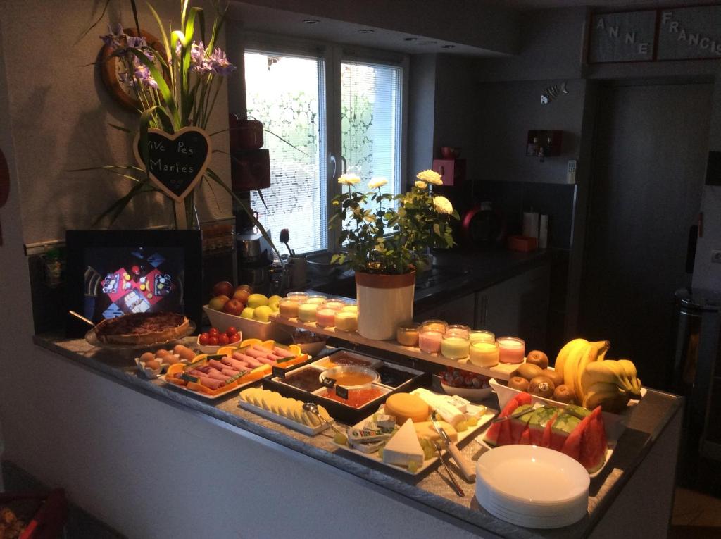 a buffet with many different types of food on a counter at Aux Neuf Saules in Mortzwiller