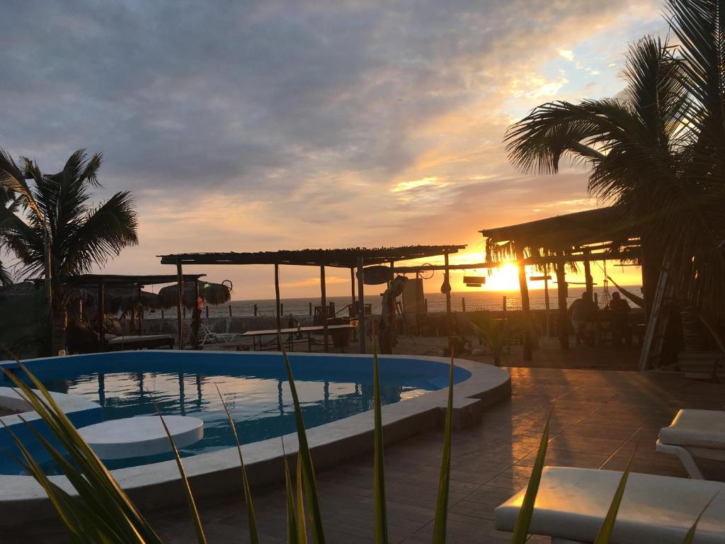 a swimming pool with the sunset in the background at Blue Ocean in Máncora