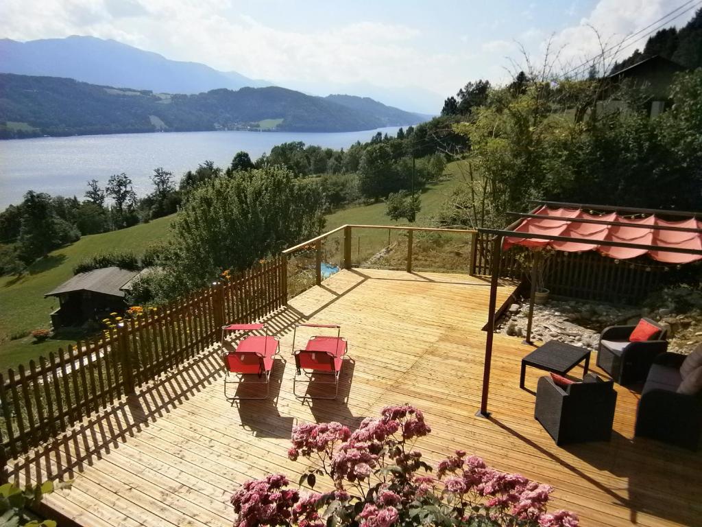 a wooden deck with chairs and a view of a lake at Apartment Haus Starfach in Döbriach