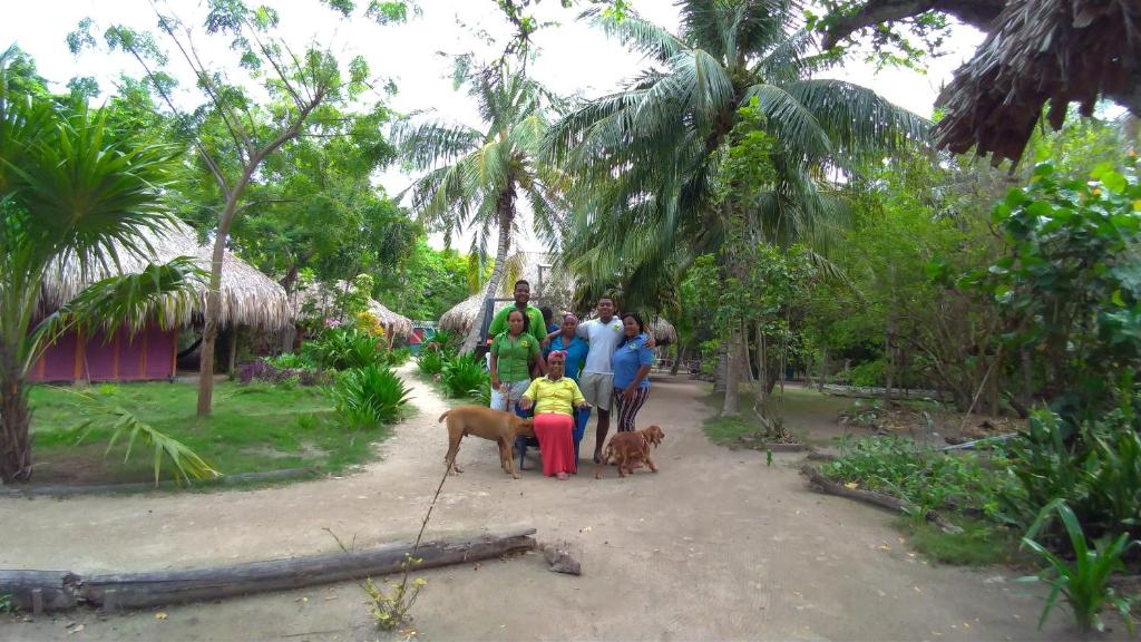 un grupo de personas con dos perros en un parque en Eco Hotel Las Palmeras, en Isla Grande