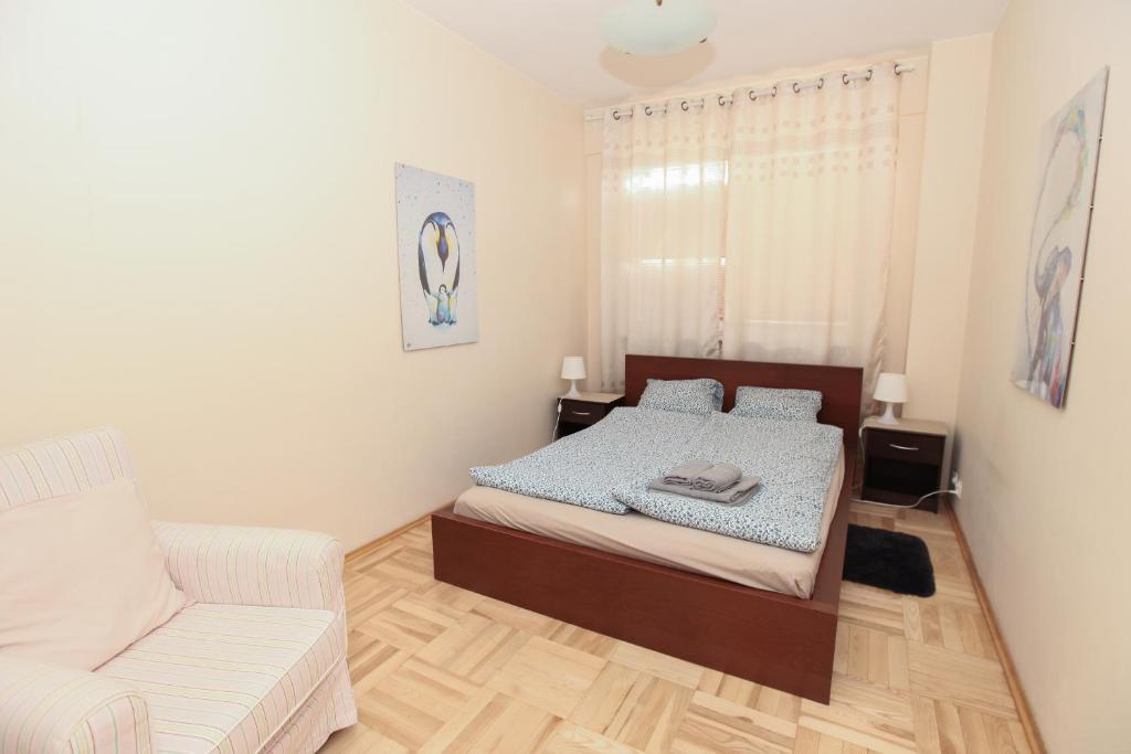 1 dormitorio pequeño con 1 cama y 1 sofá en Green Kabaty Apartment 2, en Varsovia