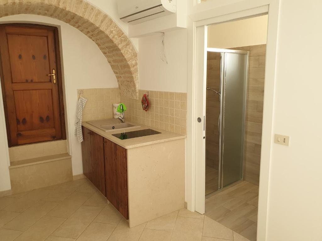 uma pequena cozinha com um lavatório e um chuveiro em Nonna Livia em Alberobello