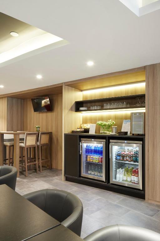 a restaurant with a refrigerator and a table and chairs at Hotel Parma in San Sebastián